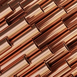 A group of copper pipes layered on top of each other