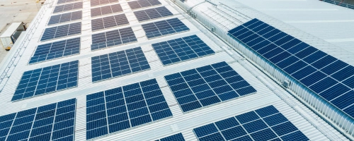 Image showing a large industrial building with the roof covered in solar panels