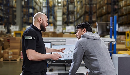 Two men talking in a warehouse