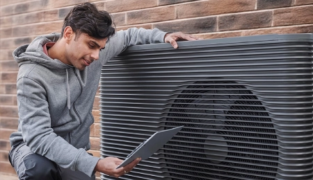 Man inspecting an outdoor HVAC unit